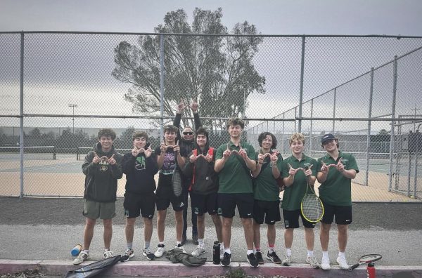 The boys tennis team holds up their Ws after their win against Casa Grade 
