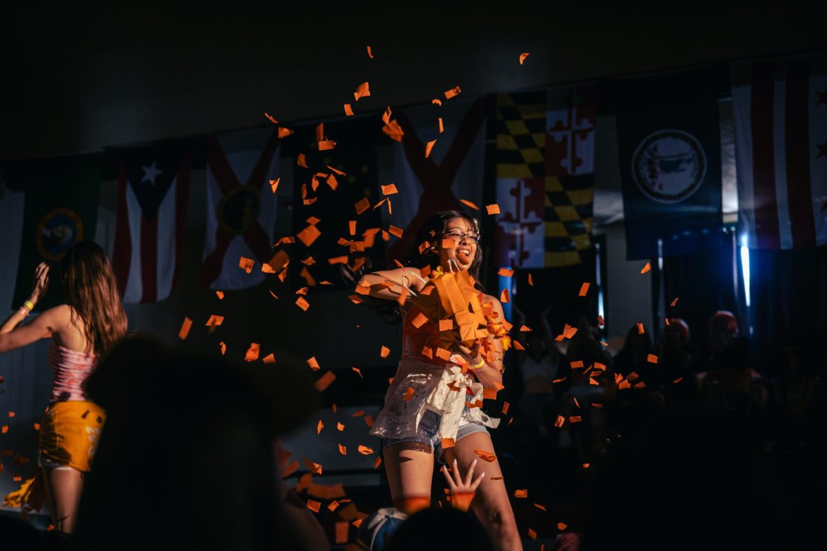 Victoria Wence throws bright orange confetti into the air