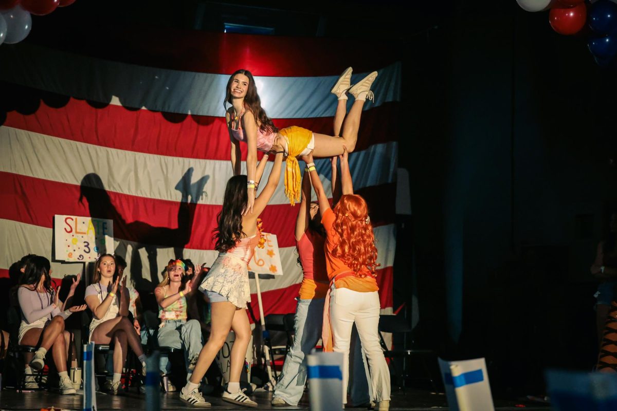 Slate 6 lifts their student voice, Savannah Rayner, into the air during their lip sync performance